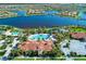 Stunning aerial view of the community clubhouse, pool, waterslide, and surrounding lush landscaping near the lake at 18861 Bianchi St, Venice, FL 34293