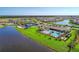An aerial view highlights the community pool, clubhouse, tennis courts, and waterfront homes in a serene, landscaped setting at 18861 Bianchi St, Venice, FL 34293