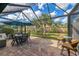 This covered lanai features an outdoor dining area with a view of the backyard at 18861 Bianchi St, Venice, FL 34293