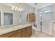 Bathroom featuring dual sinks, tile floor, walk-in shower, and sleek vanity with storage at 18861 Bianchi St, Venice, FL 34293