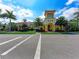 A low-angle front exterior view of a modern yellow clubhouse with an arched entryway and palm tree landscaping at 18861 Bianchi St, Venice, FL 34293