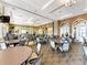 A large, open-concept dining area features round tables and chairs with neutral colors and modern lighting fixtures at 18861 Bianchi St, Venice, FL 34293