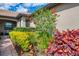 Inviting home exterior with lush landscaping, hibiscus tree and brick pathway to the front entrance at 18861 Bianchi St, Venice, FL 34293