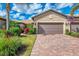 Charming single-story home featuring a two-car garage, well-manicured landscaping, and a paver driveway at 18861 Bianchi St, Venice, FL 34293