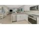 Bright open kitchen featuring stainless steel appliances, white cabinetry, marble countertops, and tiled floors at 18861 Bianchi St, Venice, FL 34293