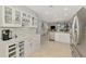 Open concept kitchen boasts stainless steel appliances, white cabinetry, marble countertops, and modern finishes at 18861 Bianchi St, Venice, FL 34293