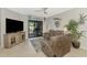 Cozy living room with plush reclining sofa, tile flooring, and sliding glass doors at 18861 Bianchi St, Venice, FL 34293
