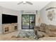 Living room featuring reclining sofa, tile flooring, and sliding glass doors to the outdoor patio at 18861 Bianchi St, Venice, FL 34293
