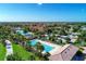 Beautiful aerial view of the community outdoor pool, clubhouse, and lush tropical landscaping at 18861 Bianchi St, Venice, FL 34293