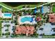 Aerial view of a community pool, clubhouse, parking, pool furniture and surrounding landscaping, an ideal outdoor retreat at 18861 Bianchi St, Venice, FL 34293