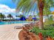Resort-style pool area with lush landscaping, comfortable lounge chairs, and a clear blue swimming pool at 18861 Bianchi St, Venice, FL 34293