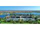 Aerial view featuring tennis courts, surrounded by lush landscaping and the lake, an ideal recreational amenity at 18861 Bianchi St, Venice, FL 34293