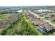 Aerial view of a community home with screened pool, lush trees, and a glimpse of a pond at 20590 Granlago Dr, Venice, FL 34293