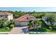 Charming single-story home with a brick driveway, tile roof, and a well-manicured front lawn with palm trees at 20590 Granlago Dr, Venice, FL 34293