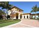 Luxury home exterior shows tile roof, immaculate landscaping and brick driveway at 20590 Granlago Dr, Venice, FL 34293