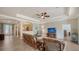 Open-concept living room with wicker furniture, ceiling fan, and decorative archways at 20590 Granlago Dr, Venice, FL 34293