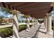 View of pergola leading to pool and clubhouse with manicured lawn and palm trees at 20590 Granlago Dr, Venice, FL 34293