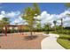 Community playground with swings surrounded by mature trees and landscaping at 20590 Granlago Dr, Venice, FL 34293