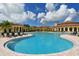 Gorgeous community pool and clubhouse surrounded by lush landscaping and sunny skies at 20590 Granlago Dr, Venice, FL 34293