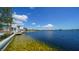Breathtaking waterfront view with vibrant blue water, lush greenery, and stunning community homes along the shore at 20590 Granlago Dr, Venice, FL 34293