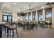 Clubhouse interior with bar, seating, and large windows overlooking a golf course at 23499 Awabuki Dr # 102, Venice, FL 34293