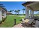 Outdoor patio furniture with a view of the golf course and palm trees at 23499 Awabuki Dr # 102, Venice, FL 34293