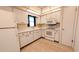 Kitchen with white cabinets, white appliances, and tile flooring at 237 Venice East Blvd, Venice, FL 34293