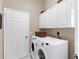 Convenient laundry room with washer, dryer, and overhead cabinets at 249 Rio Terra, Venice, FL 34285