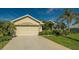 Tan single-Gathering house with attached garage and lush landscaping at 250 Long Meadow Ln, Rotonda West, FL 33947