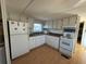 White kitchen cabinets, laminate countertops, and appliances at 269 Outer Dr, Venice, FL 34285
