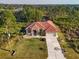 Single-Gathering home, tile roof, driveway, and large lot with surrounding vegetation at 3162 Cordova Ter, North Port, FL 34291