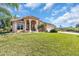 Tan house with a red tile roof, manicured lawn, and palm trees at 3162 Cordova Ter, North Port, FL 34291