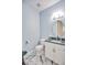 Powder bathroom with a white vanity, blue walls, and an oval mirror at 340 N River Rd, Venice, FL 34293