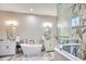 Bright bathroom featuring dual vanities, soaking tub, and glass-enclosed shower with marble accents at 340 N River Rd, Venice, FL 34293