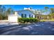 Charming home with a side-entry garage and a welcoming front porch, surrounded by lush greenery at 340 N River Rd, Venice, FL 34293