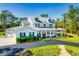 Beautiful two-story home featuring a metal roof, covered porch, and meticulously landscaped front yard at 340 N River Rd, Venice, FL 34293