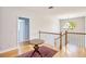 Hallway featuring hardwood floors, neutral walls, and decorative chandelier hanging between rooms at 340 N River Rd, Venice, FL 34293