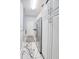 Hallway with white cabinets, marble floors, stainless steel fridge and washer/dryer hookups at 340 N River Rd, Venice, FL 34293