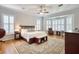 Main bedroom features wood floors, a ceiling fan, plantation shutters and a large area rug at 340 N River Rd, Venice, FL 34293