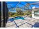 A screened-in pool features a waterfall and spa, creating a serene backyard retreat at 340 N River Rd, Venice, FL 34293