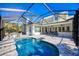 Screened-in pool with travertine tile offers a relaxing oasis, with an outdoor kitchen and dining area at 340 N River Rd, Venice, FL 34293