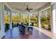 Inviting covered porch with brick flooring, ceiling fan and comfortable seating area at 340 N River Rd, Venice, FL 34293