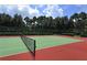 A community tennis court surrounded by lush, mature trees at 340 N River Rd, Venice, FL 34293