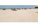 Beach scene with people relaxing under colorful umbrellas at 340 Three Lakes Ln # K, Venice, FL 34285