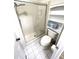 Clean bathroom featuring a glass-enclosed shower and toilet with shelving unit at 346 Mariner Dr, North Port, FL 34287