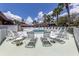 Relaxing pool area with white lounge chairs and umbrellas under a sunny blue sky with fluffy white clouds at 346 Mariner Dr, North Port, FL 34287