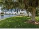 Community waterfront view with lush trees, tranquil lake, picnic benches, and seating under shaded trees at 346 Mariner Dr, North Port, FL 34287
