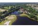 Aerial view of a community pool with a lake, golf course, and mature landscaping at 357 Marsh Creek Rd, Venice, FL 34292