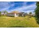 View of a large backyard featuring lush green grass, a screened-in lanai, and well-maintained landscaping at 357 Marsh Creek Rd, Venice, FL 34292