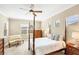 Bright bedroom with four-poster bed, neutral walls, and natural light from two windows at 357 Marsh Creek Rd, Venice, FL 34292